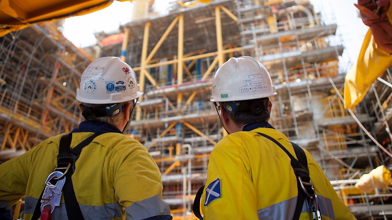 Two men looking at construction of a platform
