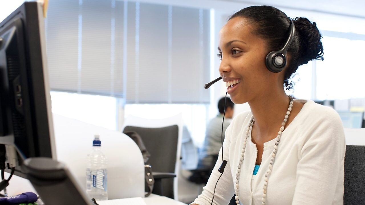 Woman in call centre facing her computer screen