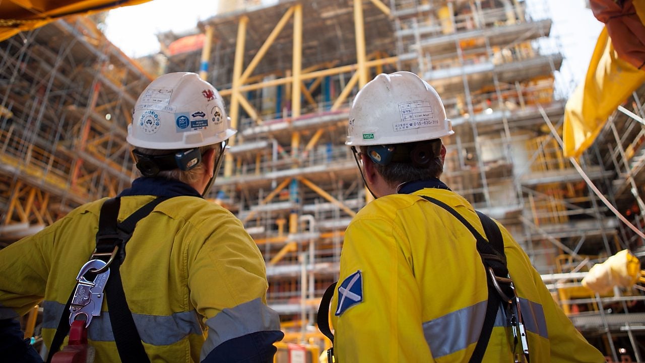 Two men looking at construction of a platform