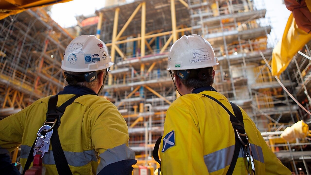 Two men looking at construction of a platform