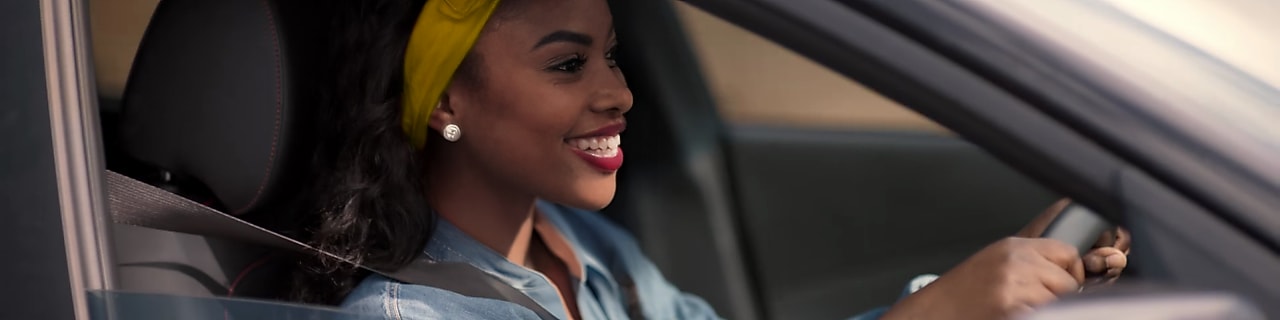 Girl smiling and driving in car