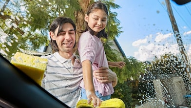Father and daughter cleaning the car