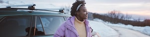 Photo of a young African American woman on a winter road trip.