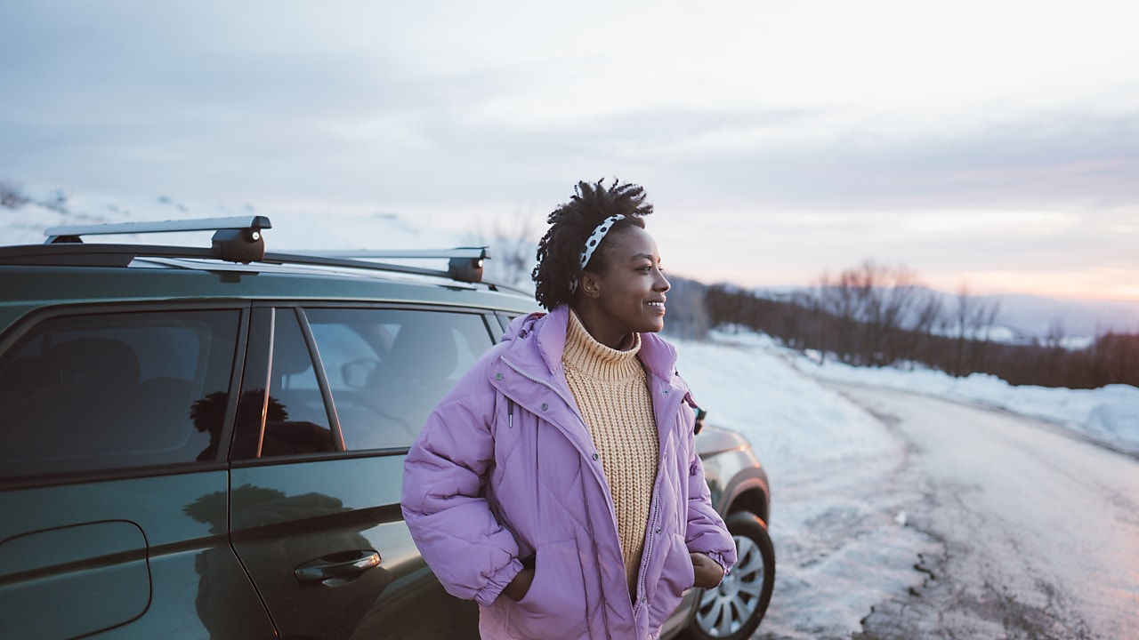 Photo of a young African American woman on a winter road trip.