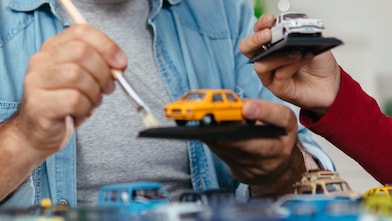 Father and son painting mini model cars