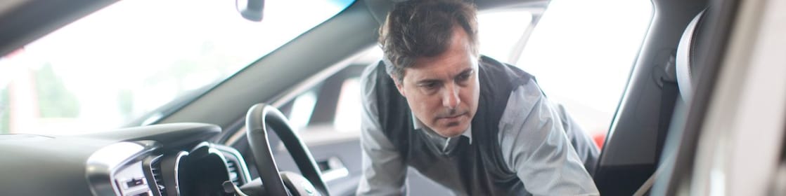 Man looking inside a car