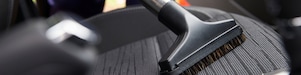 person vacuuming the car seat