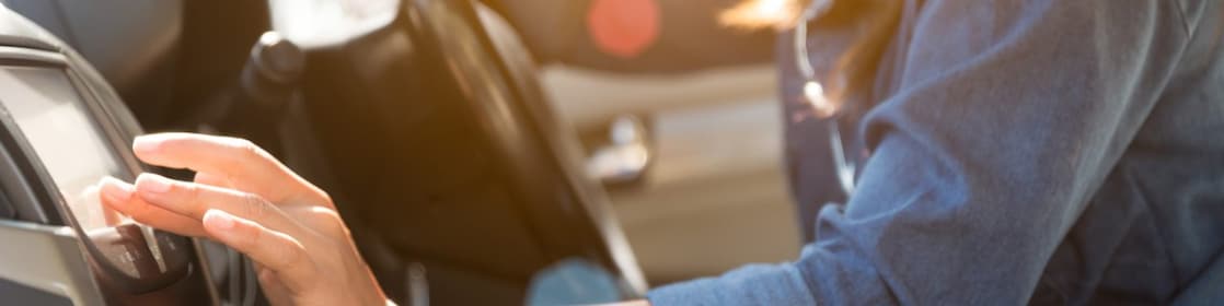 Woman selects a podcast on a car’s infotainment system.