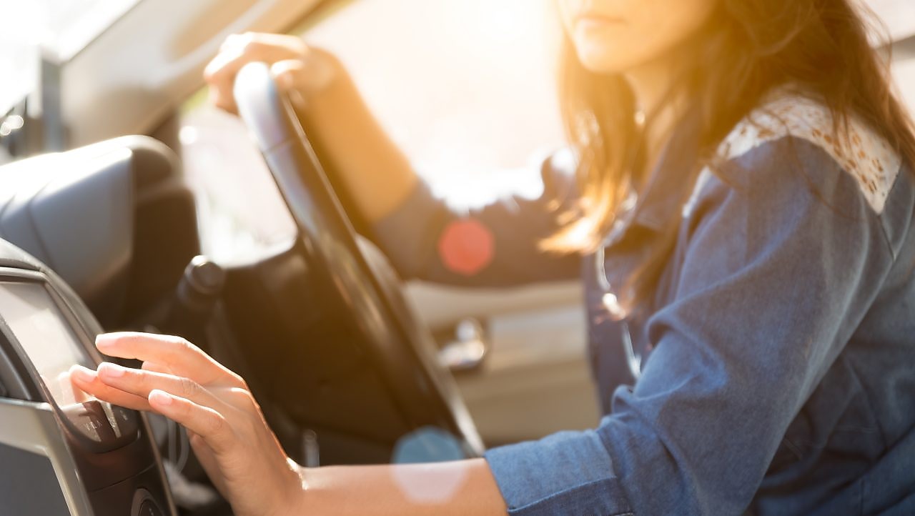 Woman selects a podcast on a car’s infotainment system.