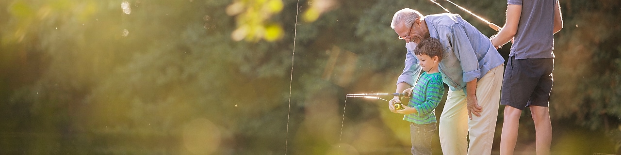 Grandpa, son and grandson fishing by the lake