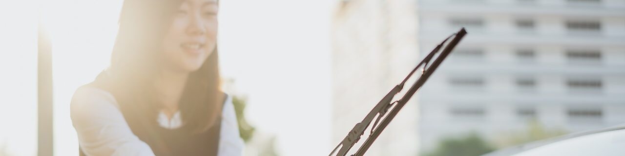 woman fixing front windscreen wiper blade