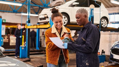 Female garage owner with repair bill for customer