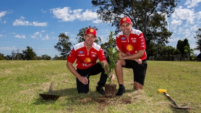 Race team member planting a tree in a park