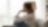 Young lady sitting on couch with knees tucked and face turned away