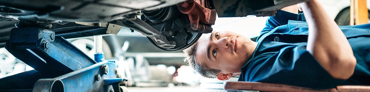 Car Mechanic Working Under Vehicle