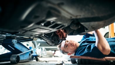 Car Mechanic Working Under Vehicle