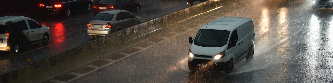 White van driving in the rain at night