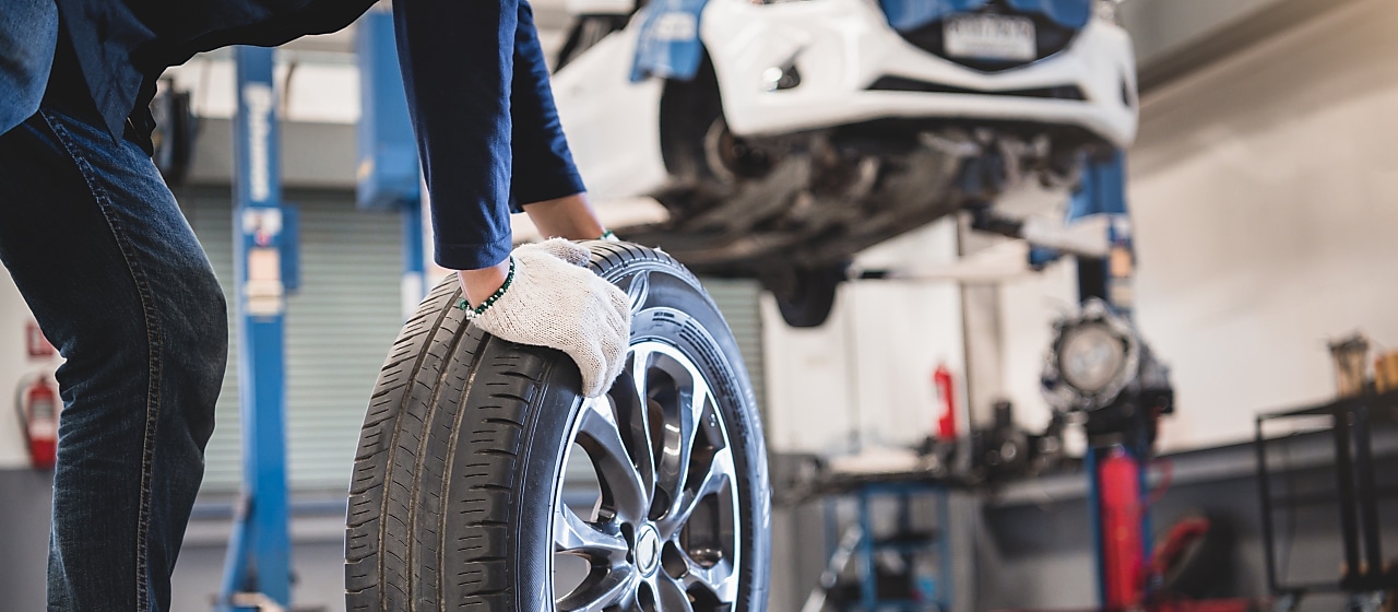 Mechanic wheeling a tyre