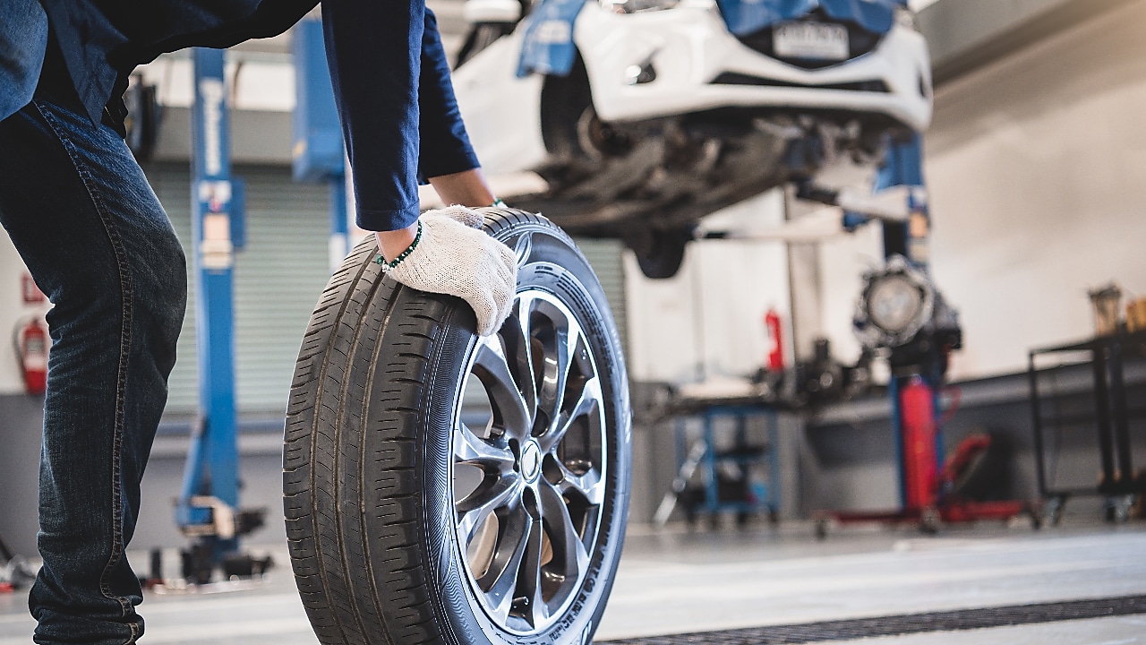 Mechanic wheeling a tyre