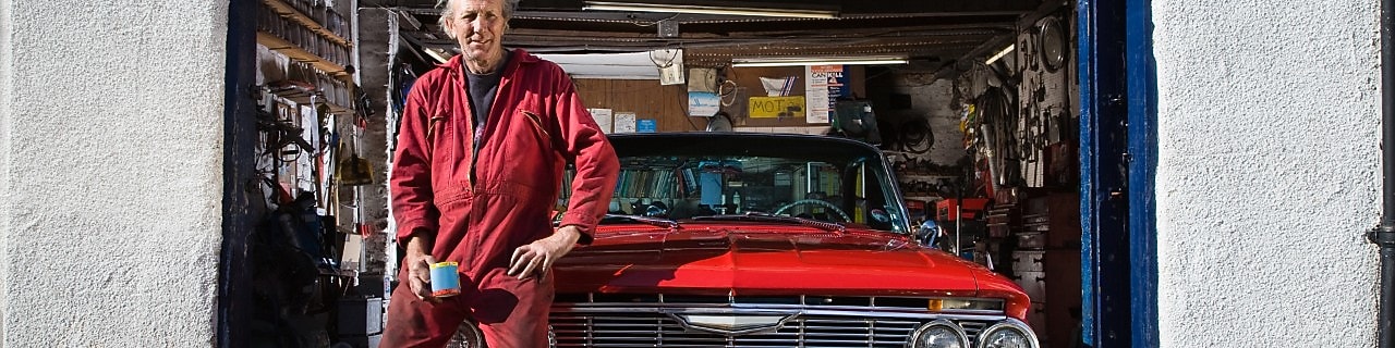Man sitting on red cars bonnet