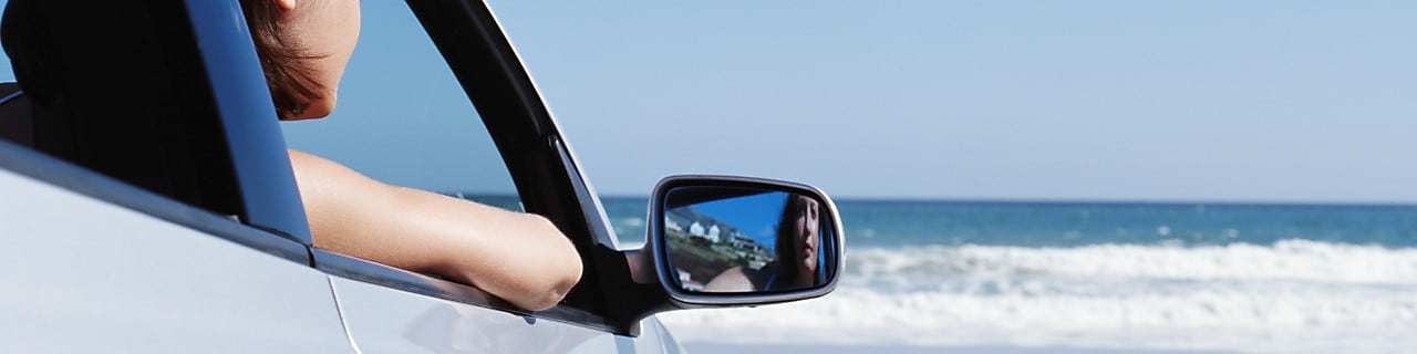 woman in non-moving car looking out to the sea