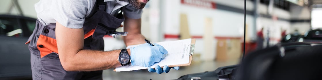 Man looking under the bonnet of car and doing safety check