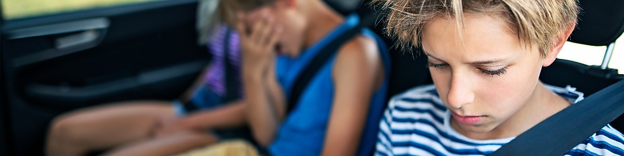 Car trip with three kids. Kids getting bored from long trips and nauseous from car sickness.