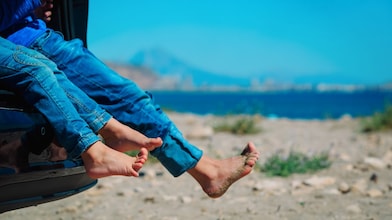 Children in a car with sand on their feet