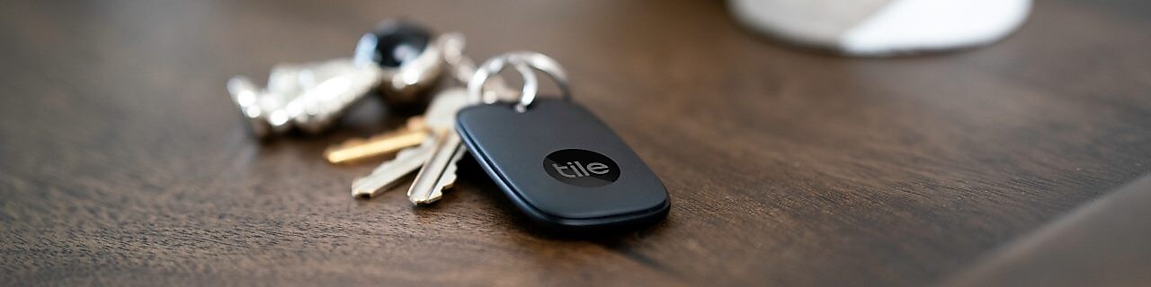 Set of keys on a table with a Tile Bluetooth tracker