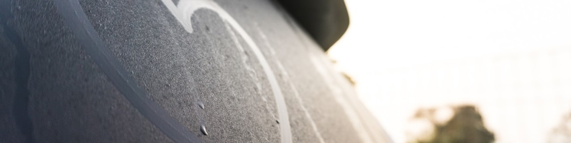A close-up view of a heart drawn into the condensation on a car’s rear windscreen.