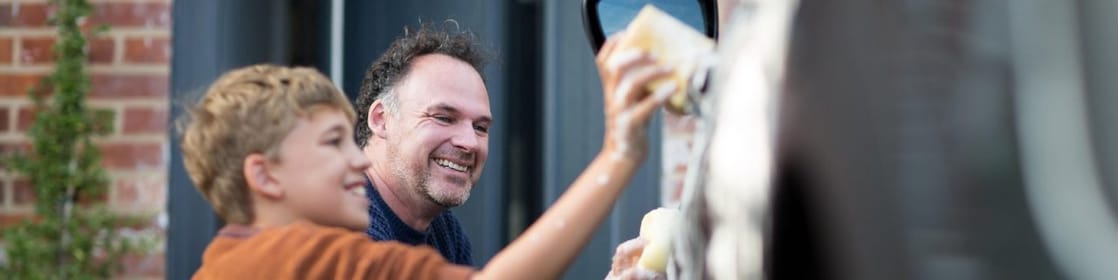 Man and boy washing car