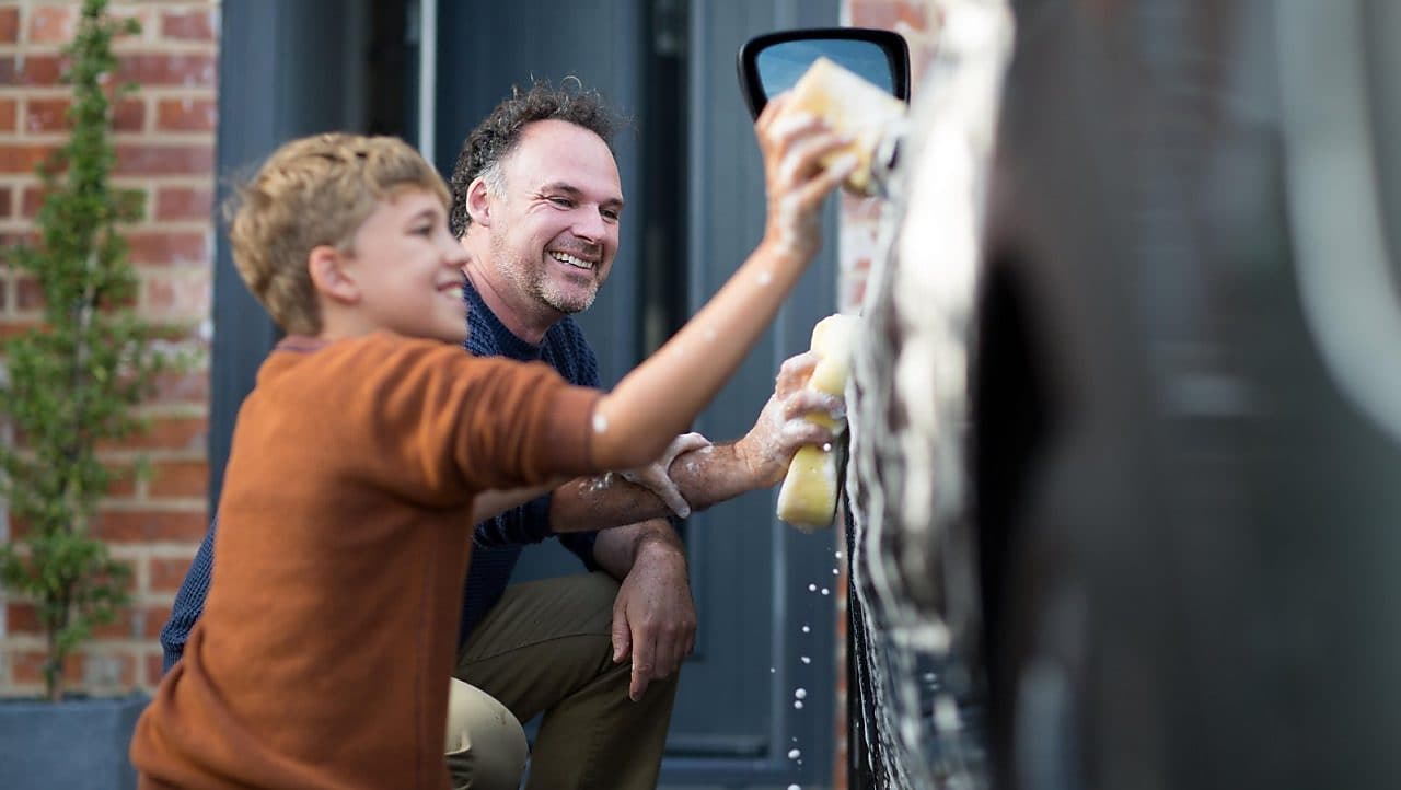 Man and boy washing car