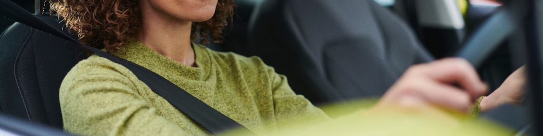 Woman driving with hands on steering wheel