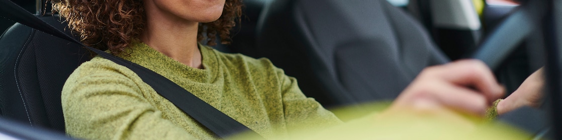 Woman driving with hands on steering wheel