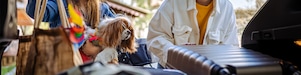Safe and scree-free road trips: Mother and daughter packing bags at the boot of car