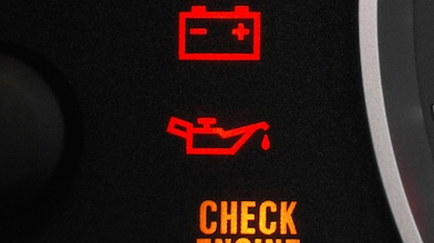 A detailed view of a car dashboard featuring a glowing check engine light, signaling the need for vehicle maintenance.