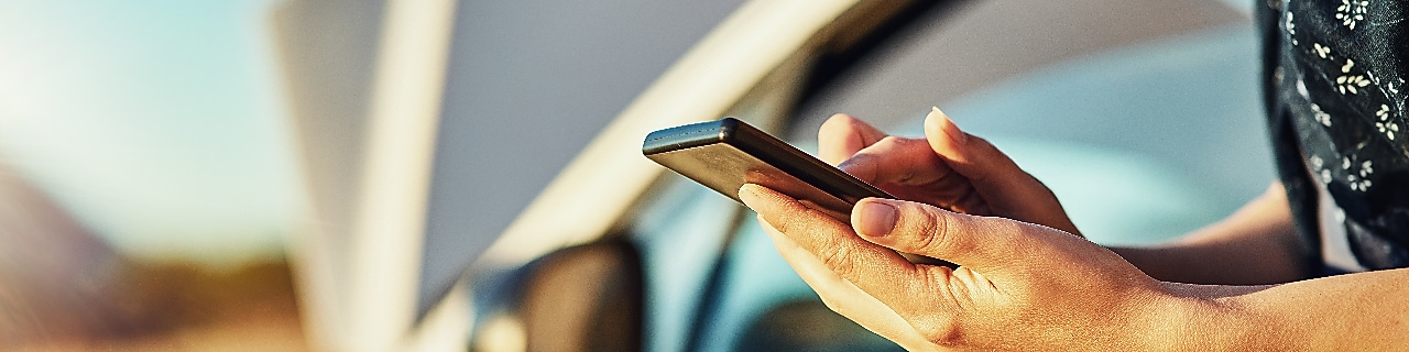 Cropped shot of an unidentifiable woman contacting roadside assistance after breaking down