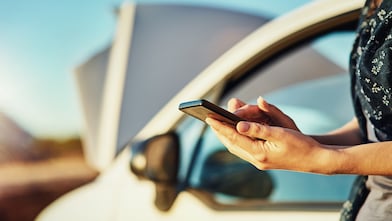 Cropped shot of an unidentifiable woman contacting roadside assistance after breaking down