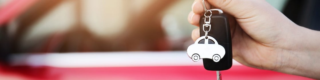 A person holds keys to a new car