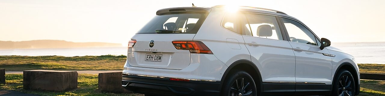 A white Volkswagen Tiguan Allspace parked in a waterfront carpark