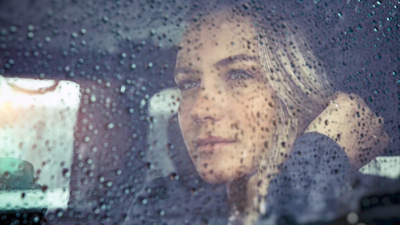 Woman looking out the window on a rainy day