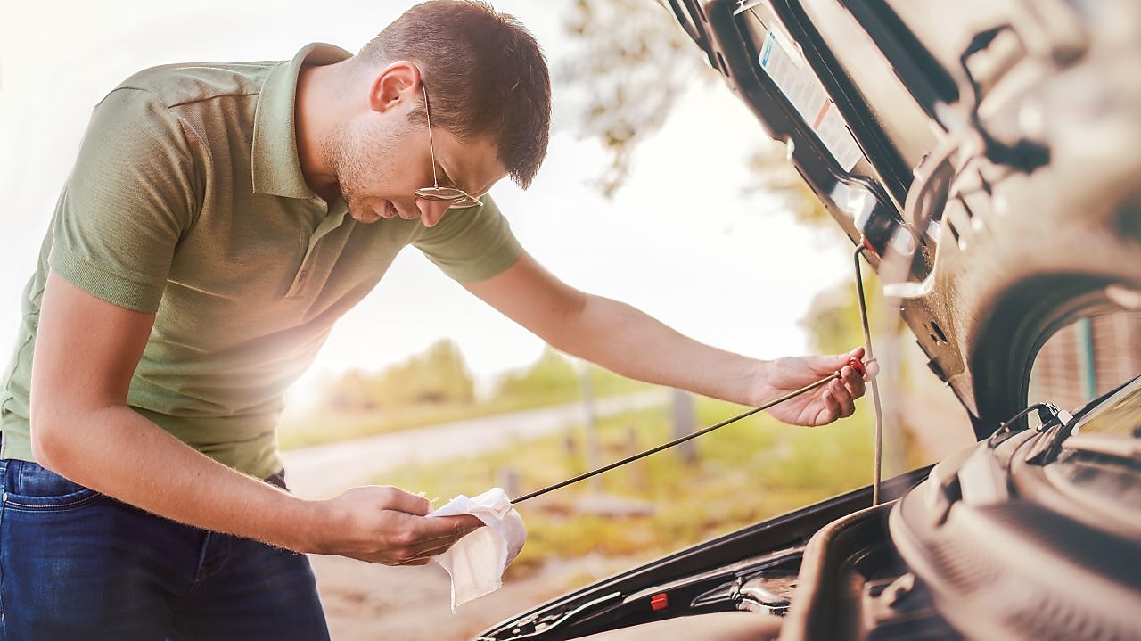 Man checking oil in car