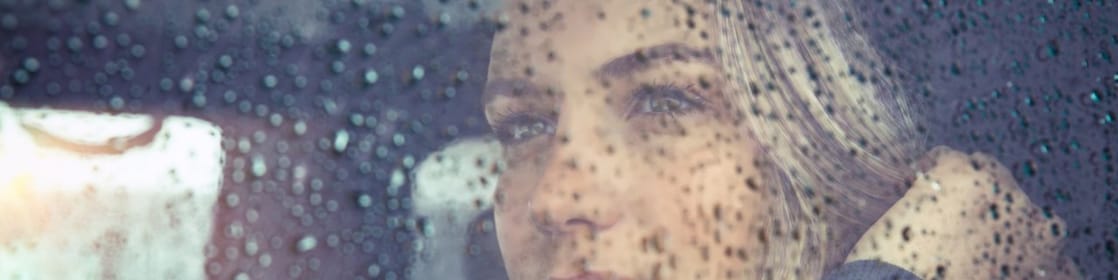 Woman looking out the window on a rainy day