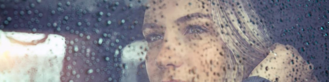 Woman looking out the window on a rainy day