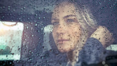 Woman looking out the window on a rainy day