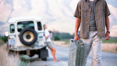 Man walking down the road with a jerry can