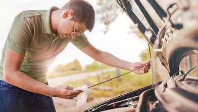 Man checking oil in car