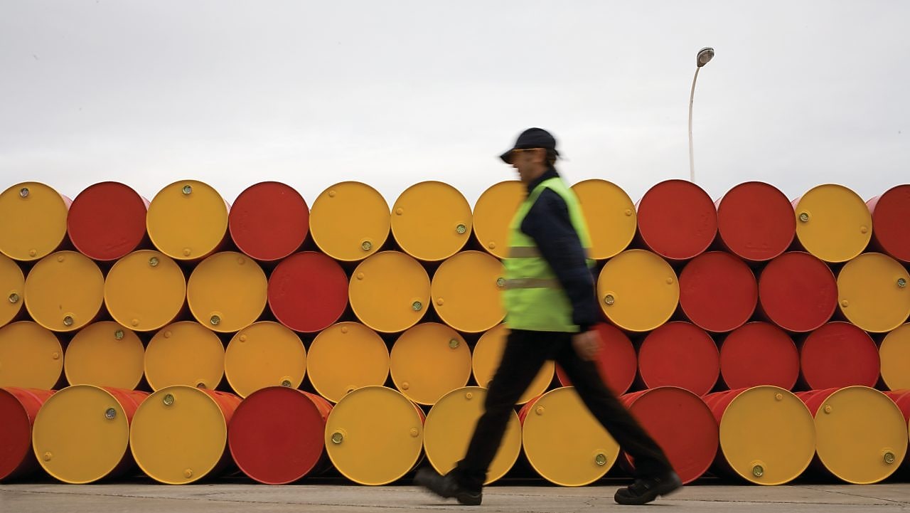 Man walking past barrels of Lubricants