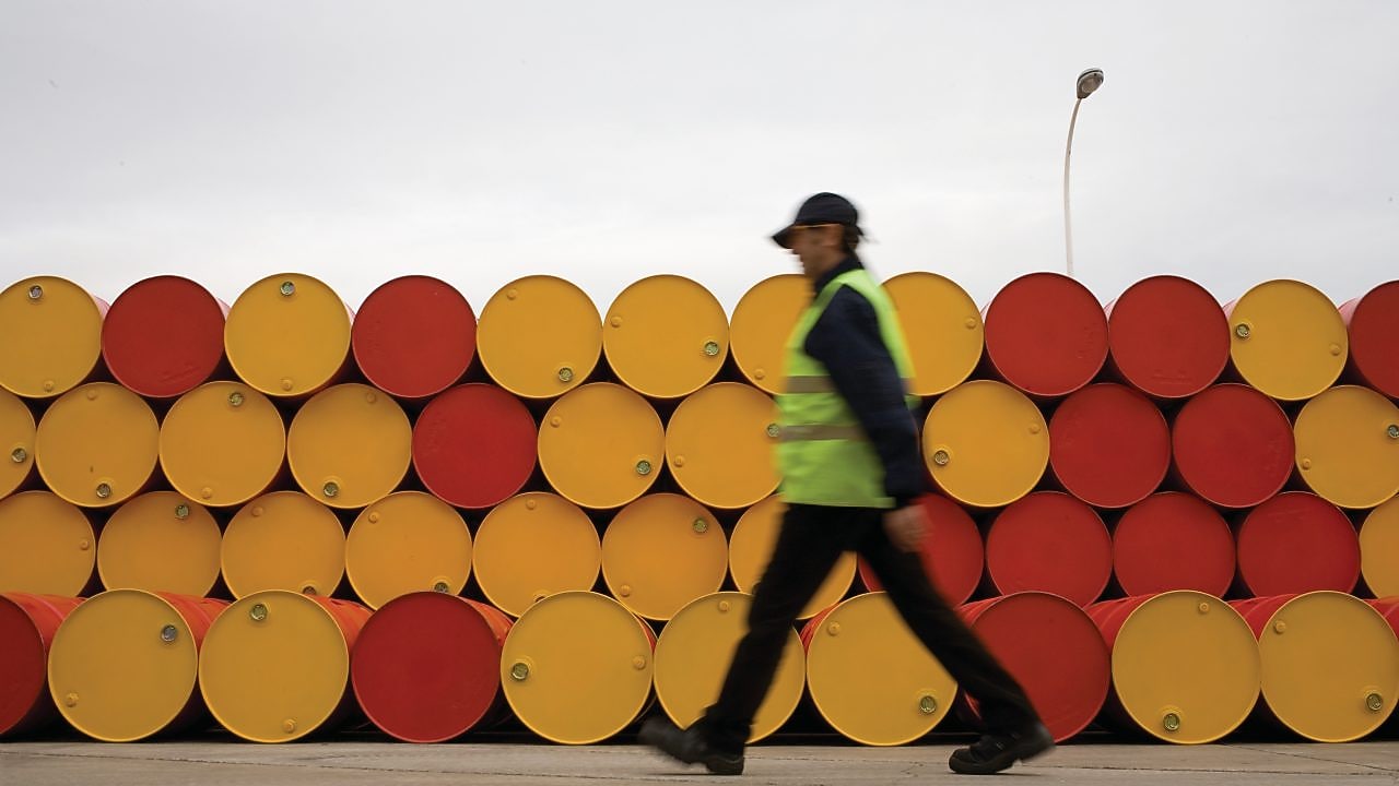 Man walking past barrels of Lubricants
