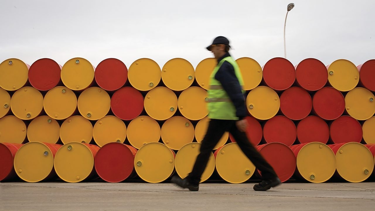 Man walking past barrels of Lubricants